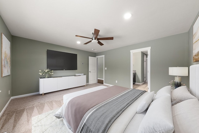 bedroom featuring recessed lighting, light colored carpet, a ceiling fan, ensuite bath, and baseboards