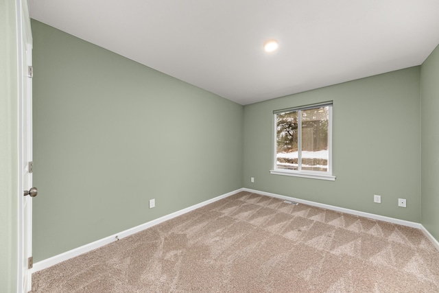 unfurnished room with carpet floors, visible vents, and baseboards