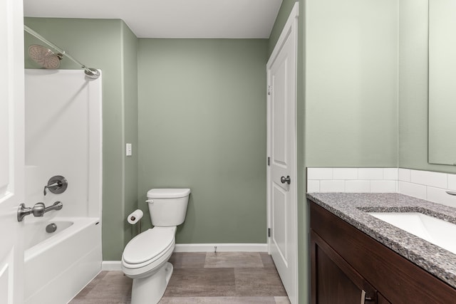 full bath with baseboards, toilet, vanity, and shower / tub combination