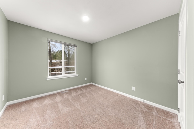 carpeted empty room featuring visible vents and baseboards