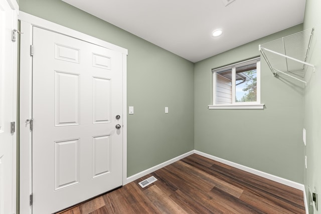 interior space with dark wood-style flooring, visible vents, and baseboards