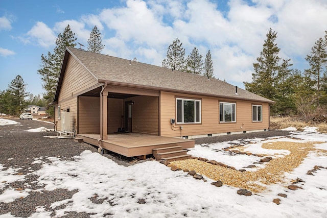 rear view of house with a deck and a shingled roof