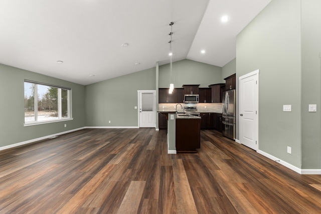 kitchen with a center island with sink, stainless steel appliances, dark wood-type flooring, open floor plan, and dark brown cabinets