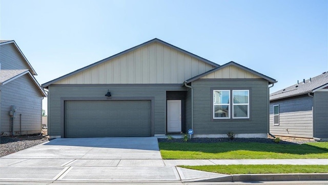 view of front of property featuring a front yard, concrete driveway, and an attached garage