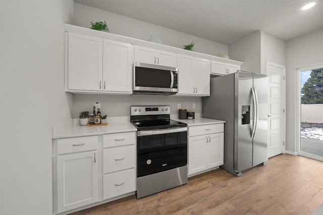 kitchen featuring light wood-style floors, white cabinetry, stainless steel appliances, and light countertops