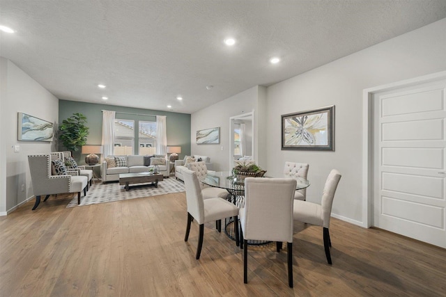 dining space with a textured ceiling, baseboards, wood finished floors, and recessed lighting