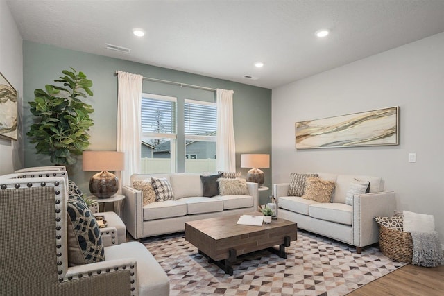 living area with light wood-type flooring, visible vents, and recessed lighting