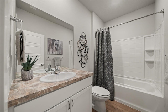 bathroom with toilet, wood finished floors, shower / bath combination with curtain, and vanity