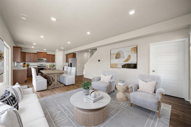 living room with recessed lighting, stairway, and wood finished floors