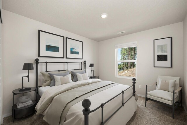 carpeted bedroom featuring baseboards, visible vents, and a textured ceiling