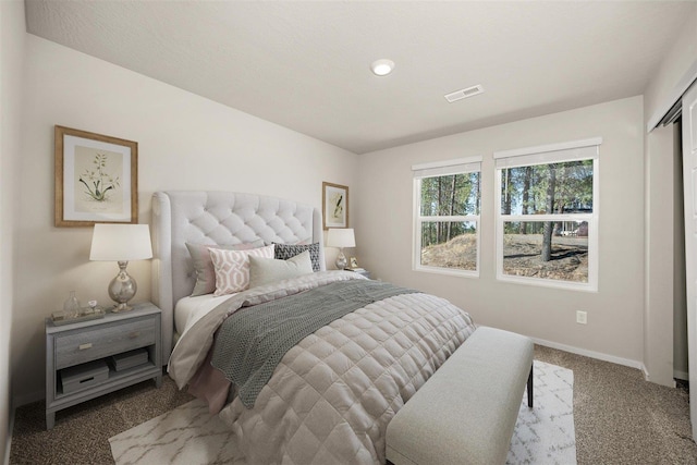 carpeted bedroom with visible vents and baseboards