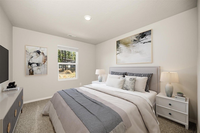 bedroom with carpet floors, visible vents, a textured ceiling, and baseboards