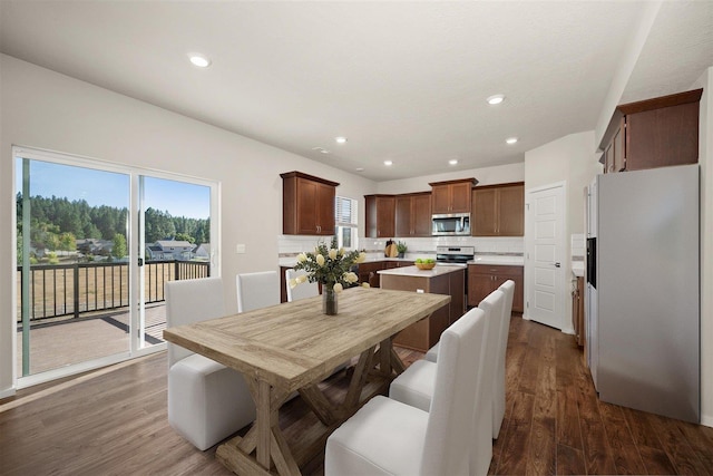 dining room featuring a healthy amount of sunlight, dark wood-style floors, and recessed lighting