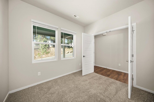 unfurnished bedroom featuring carpet floors, visible vents, and baseboards