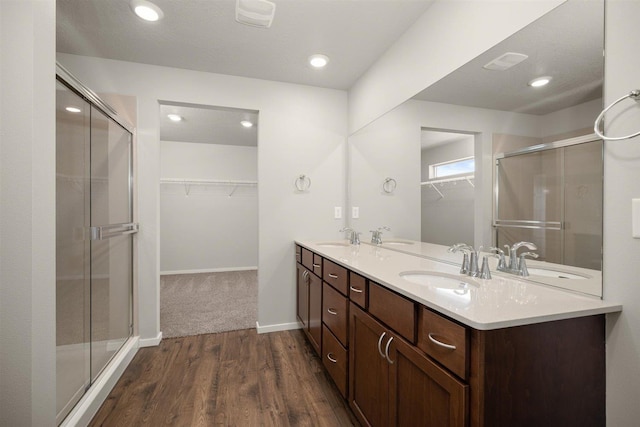 bathroom with wood finished floors, a sink, and double vanity