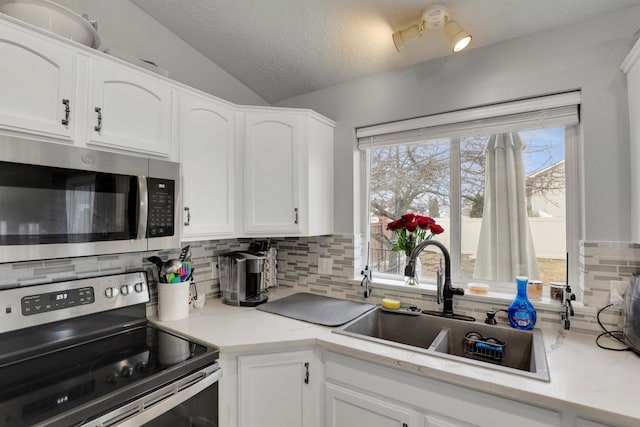 kitchen featuring light countertops, appliances with stainless steel finishes, and white cabinetry