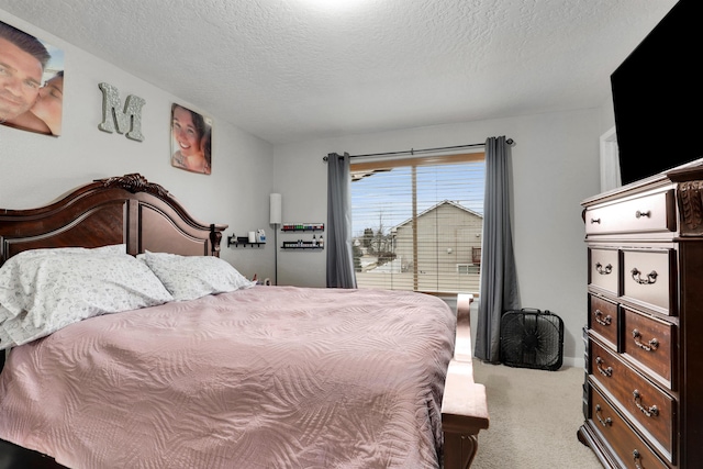 bedroom featuring light carpet and a textured ceiling