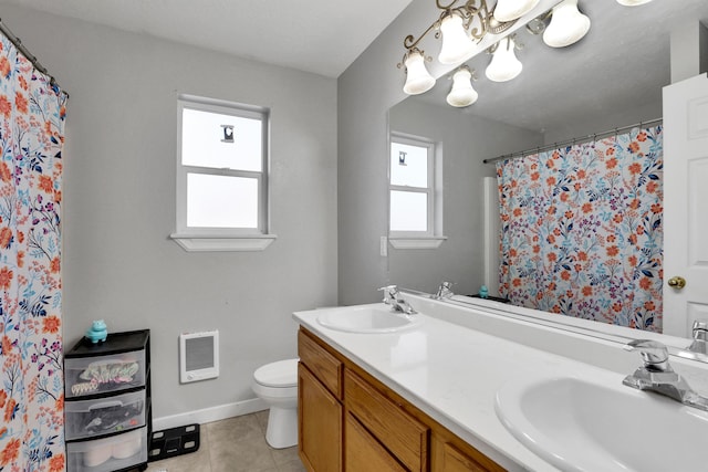 bathroom featuring double vanity, a sink, toilet, and tile patterned floors