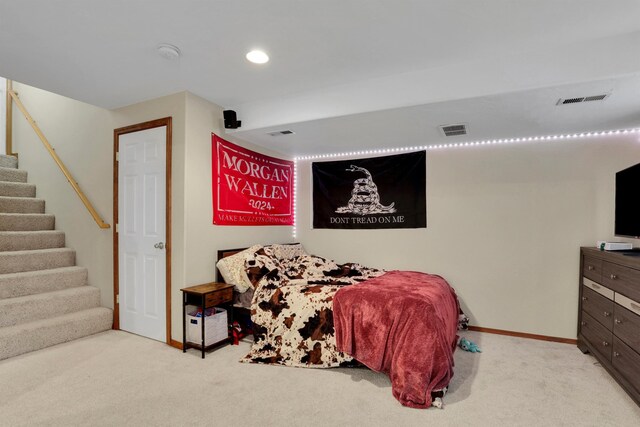 bedroom with baseboards, visible vents, and light colored carpet