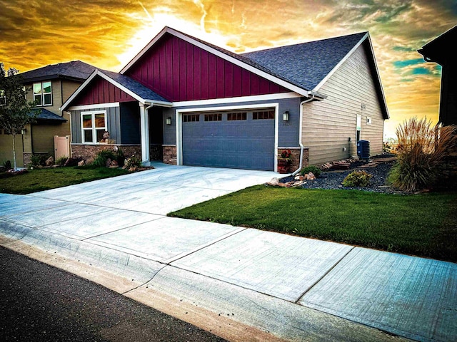 craftsman house with central air condition unit, concrete driveway, board and batten siding, a front yard, and a garage