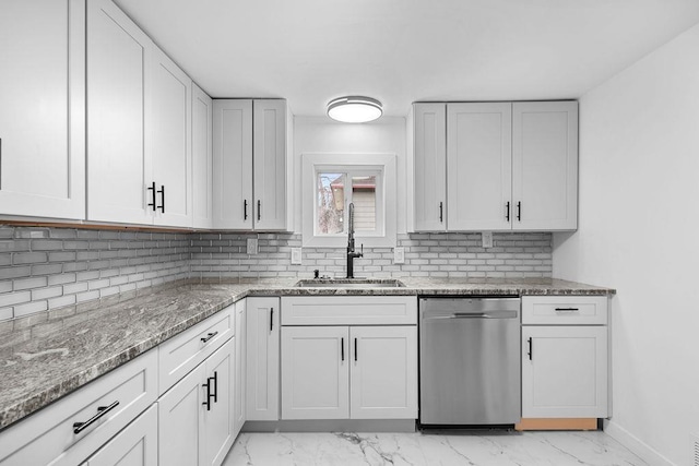 kitchen featuring light stone counters, marble finish floor, backsplash, stainless steel dishwasher, and a sink