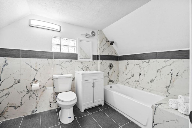 bathroom with lofted ceiling, a textured ceiling, toilet, vanity, and a tub