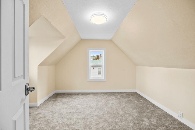 bonus room featuring lofted ceiling, carpet floors, and baseboards