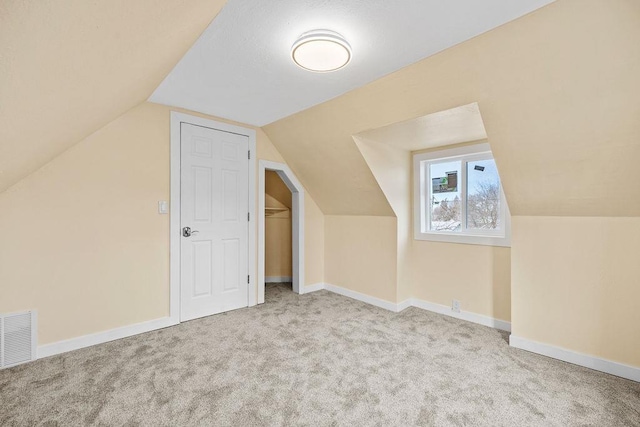 bonus room featuring carpet floors, baseboards, visible vents, and lofted ceiling