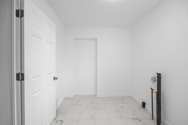 washroom featuring marble finish floor, baseboards, and laundry area