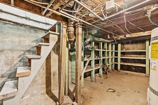 unfinished basement with stairs and electric water heater