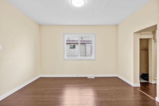 unfurnished bedroom with visible vents, baseboards, and wood finished floors