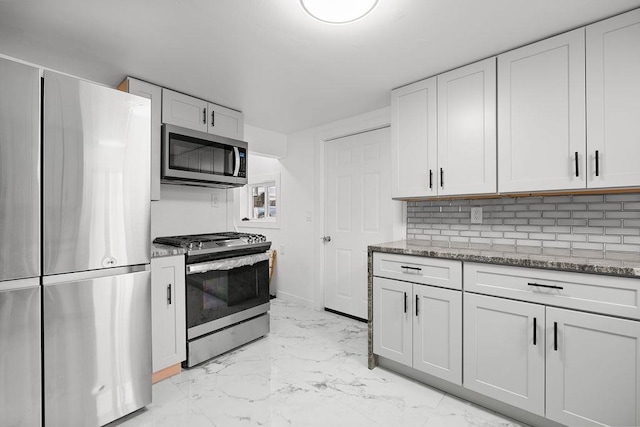 kitchen featuring stainless steel appliances, marble finish floor, backsplash, and light stone countertops