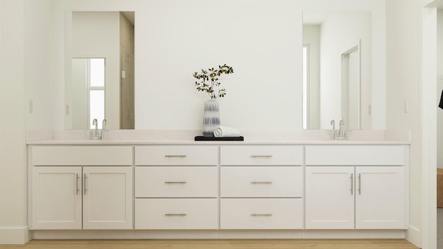 full bath with wood finished floors, a sink, and double vanity