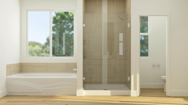 full bathroom featuring toilet, a stall shower, a bath, and wood finished floors