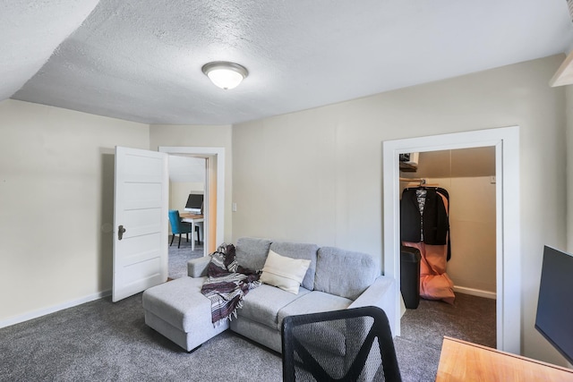 living area featuring carpet, a textured ceiling, and baseboards