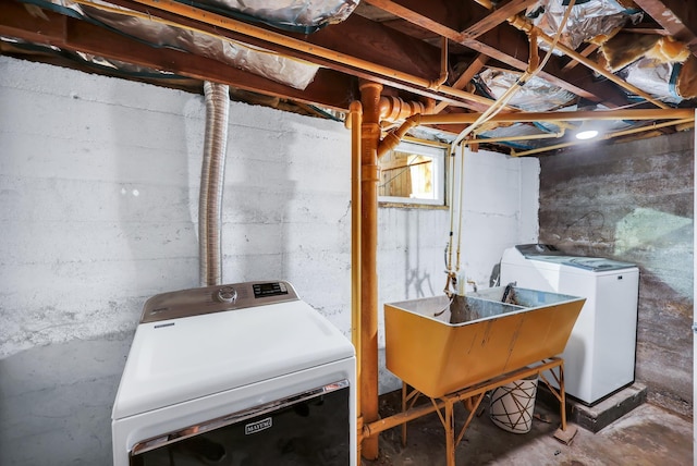 below grade area featuring washer and clothes dryer and a sink