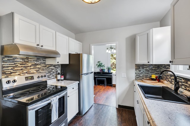 kitchen with stainless steel appliances, light countertops, dark wood-type flooring, a sink, and under cabinet range hood