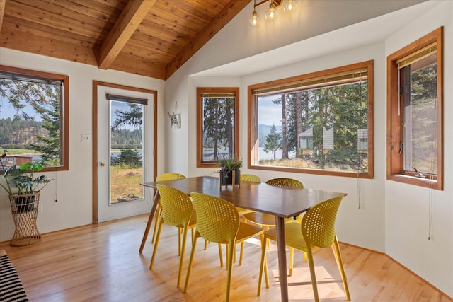 dining room with vaulted ceiling with beams, light wood-style flooring, and wood ceiling