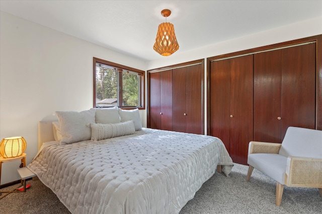 bedroom with carpet flooring and multiple closets