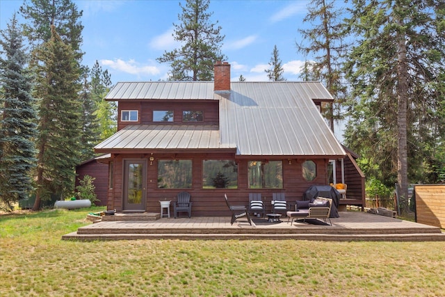 rear view of property with metal roof, outdoor lounge area, a yard, and a chimney