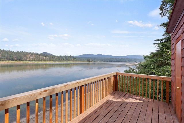 wooden deck with a water and mountain view