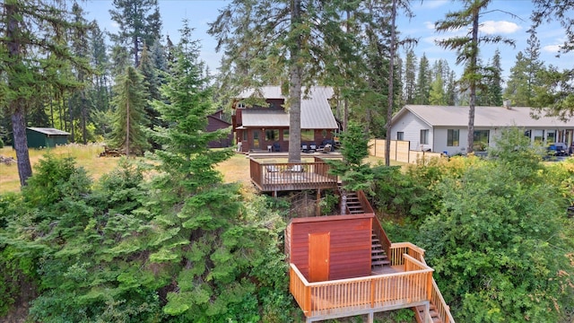 exterior space featuring stairs, metal roof, and a wooden deck