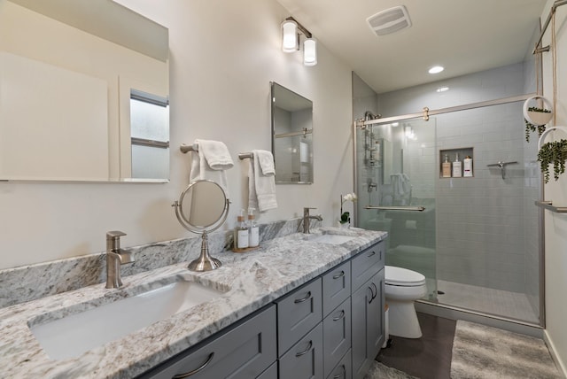 full bath featuring visible vents, a sink, a shower stall, and toilet