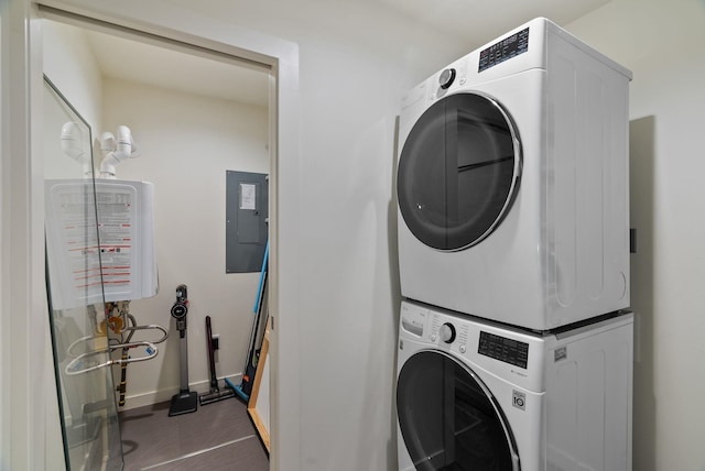 washroom with laundry area, stacked washer / dryer, electric panel, and baseboards