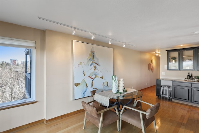 dining space with light wood-type flooring and baseboards