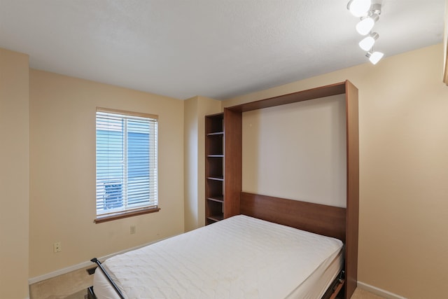 bedroom featuring light carpet and baseboards