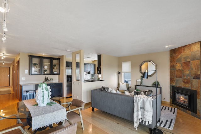 living room with a tiled fireplace and light wood-style floors