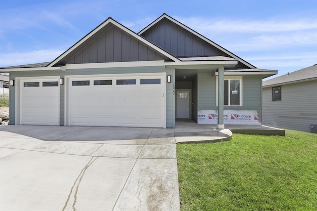 view of front of home with an attached garage, a front yard, board and batten siding, and concrete driveway