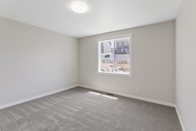 carpeted empty room with visible vents and baseboards