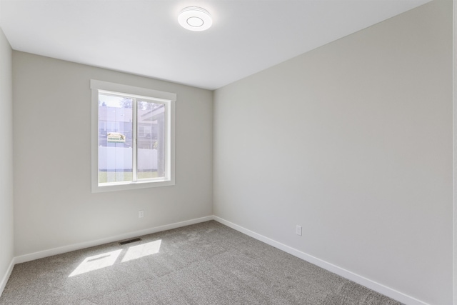 carpeted empty room with visible vents and baseboards